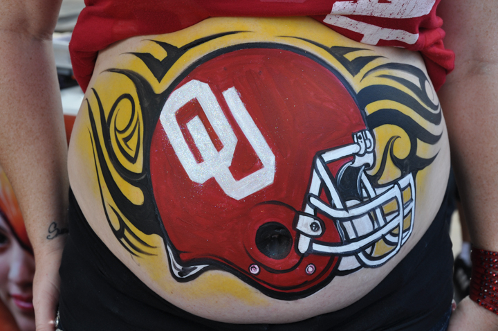 a woman with an OU painting on her pregnant belly